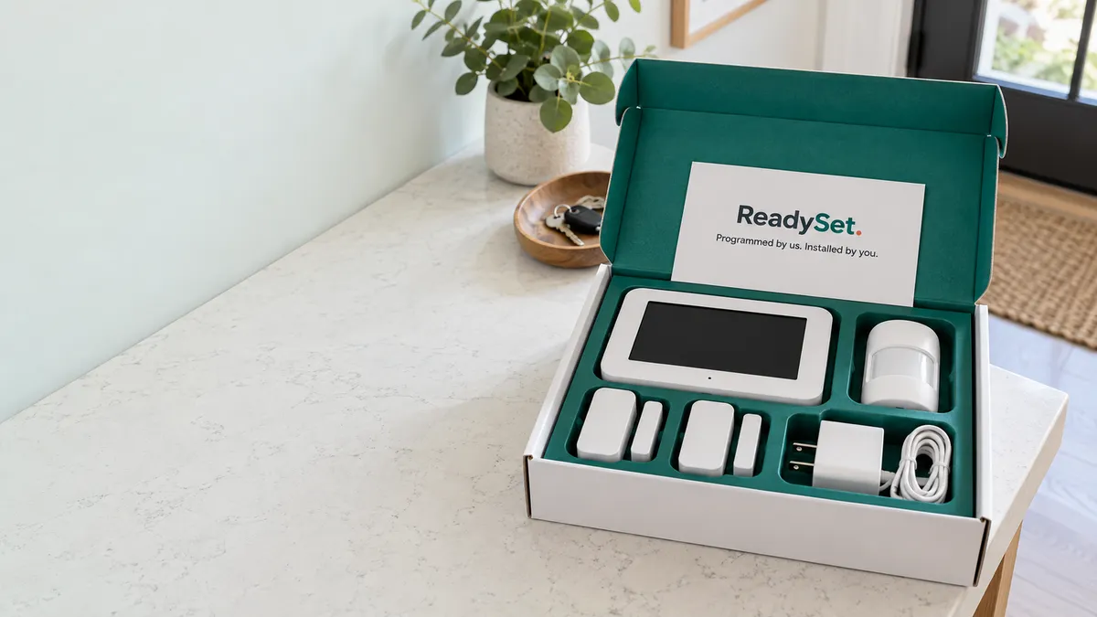 Illustrative concept of a ReadySet alarm kit prepared for shipping, with a touchscreen hub and sensors